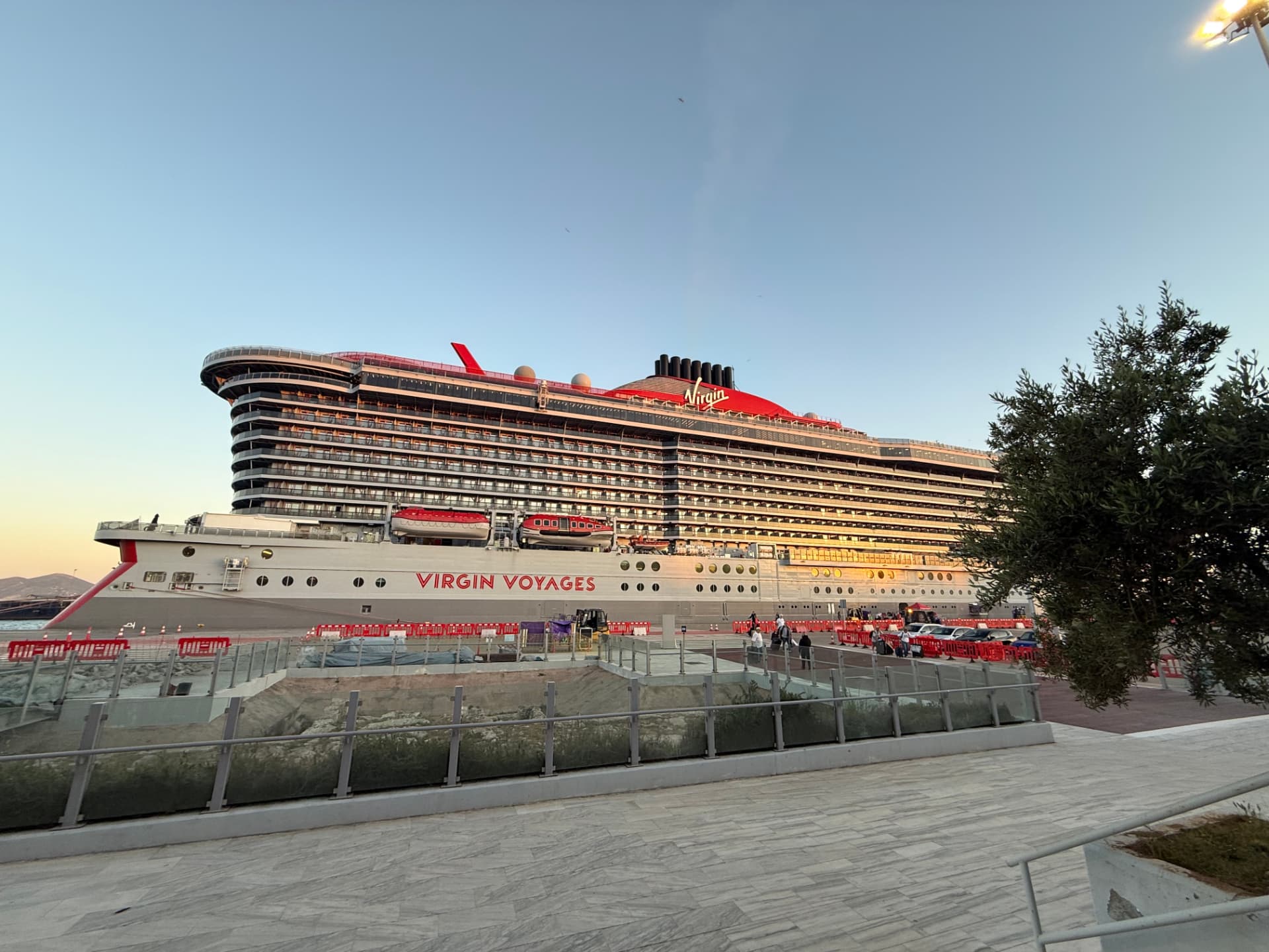 Virgin Voyages ship docked at sunset in a Mediterranean port